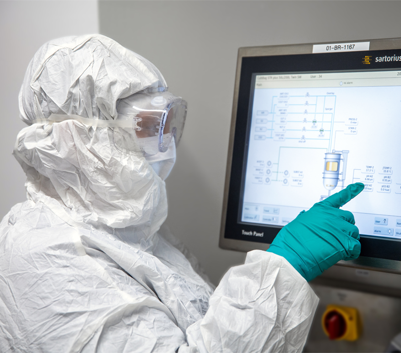 Viral vector manufacturing services worker using a touchscreen on machinery at center for breakthrough medicine’s CDMO facility